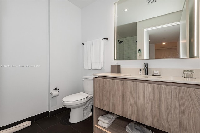 bathroom featuring tiled shower, tile patterned flooring, vanity, and toilet