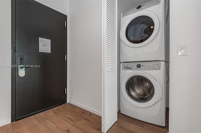 laundry area with stacked washer and clothes dryer and wood-type flooring