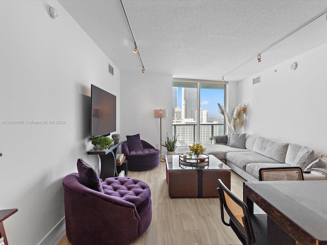 1900 N Bayshore Dr Unit 1704, Miami, FL 33132 - living room featuring track lighting, light wood finished floors, a textured ceiling, expansive windows, and baseboards