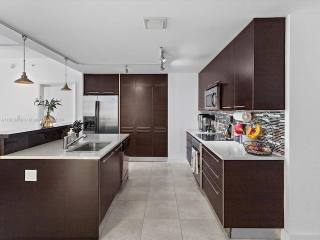 kitchen featuring decorative backsplash, sink, dark brown cabinets, pendant lighting, and appliances with stainless steel finishes