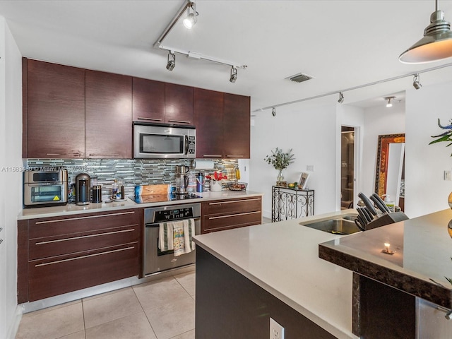 kitchen featuring stainless steel appliances, light tile patterned flooring, sink, rail lighting, and decorative backsplash