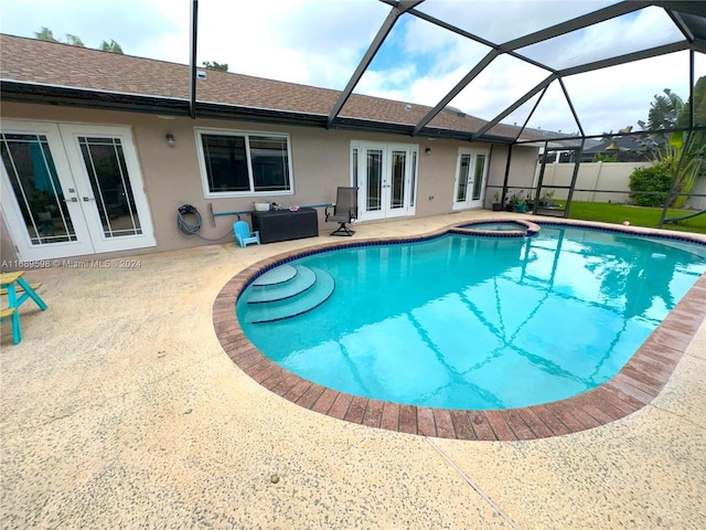 view of swimming pool featuring a patio, french doors, a lanai, and an in ground hot tub