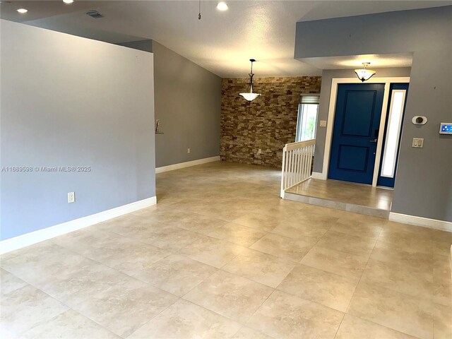 kitchen featuring light stone counters, a textured ceiling, sink, stainless steel dishwasher, and light tile patterned flooring