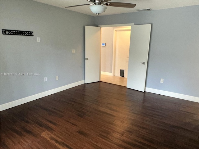 empty room featuring ceiling fan and dark hardwood / wood-style flooring