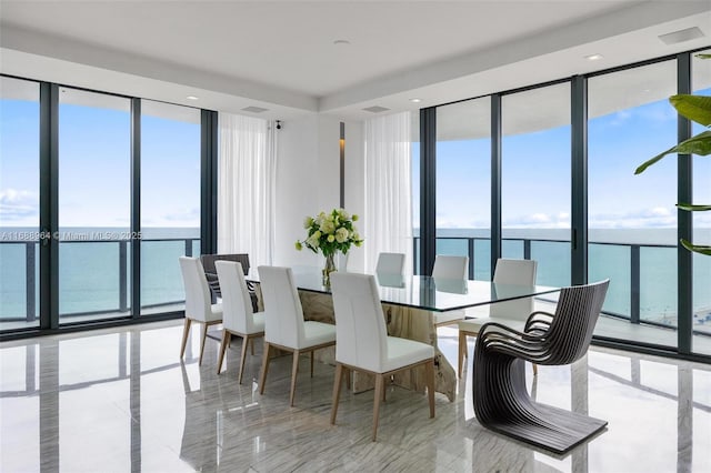 dining room featuring expansive windows, a water view, and a wealth of natural light