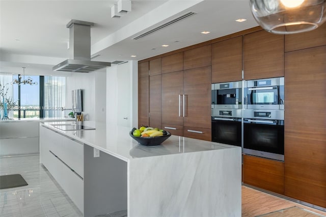 kitchen featuring black electric stovetop, double oven, a spacious island, exhaust hood, and a chandelier