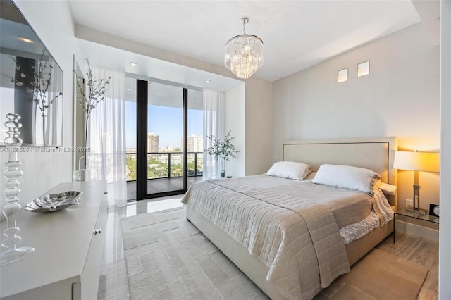 bedroom featuring access to outside, expansive windows, and an inviting chandelier