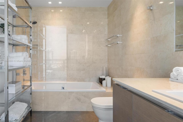 full bathroom featuring tiled shower / bath combo, toilet, tile walls, and vanity