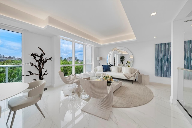 living room featuring a tray ceiling and plenty of natural light