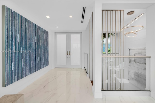 entrance foyer with an inviting chandelier and french doors