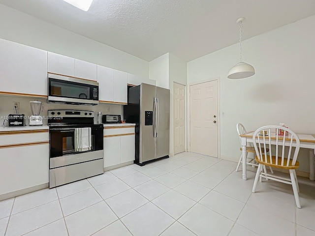 kitchen featuring hanging light fixtures, white cabinets, a textured ceiling, light tile patterned flooring, and appliances with stainless steel finishes