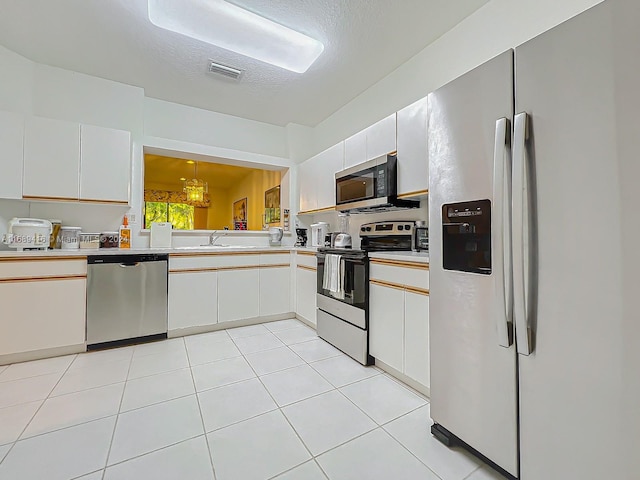 kitchen with white cabinets, pendant lighting, and appliances with stainless steel finishes