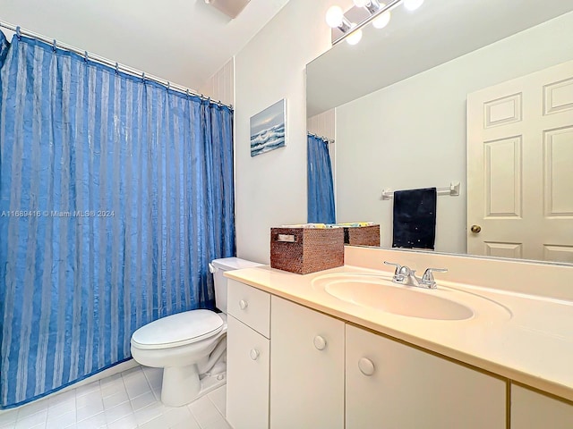 bathroom featuring toilet, vanity, tile patterned floors, and curtained shower