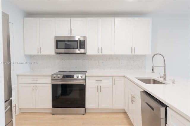 kitchen featuring white cabinetry, light wood-type flooring, appliances with stainless steel finishes, and sink