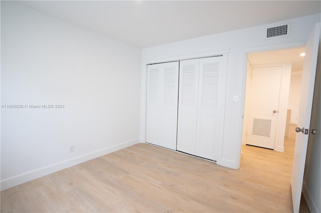 unfurnished bedroom with light hardwood / wood-style floors and a closet