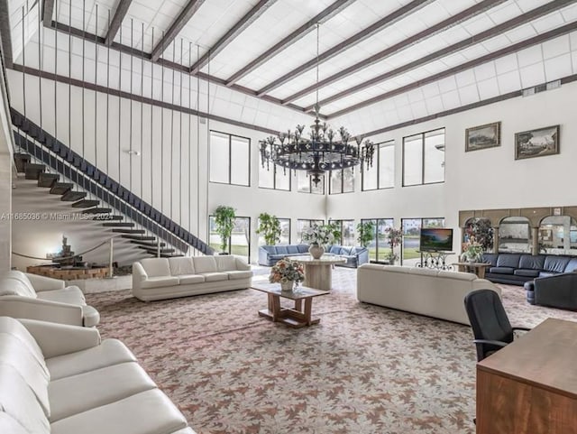 carpeted living room with a notable chandelier, a high ceiling, and beam ceiling