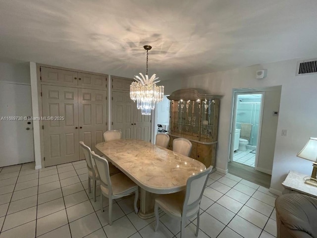 dining space featuring light tile patterned floors and a chandelier