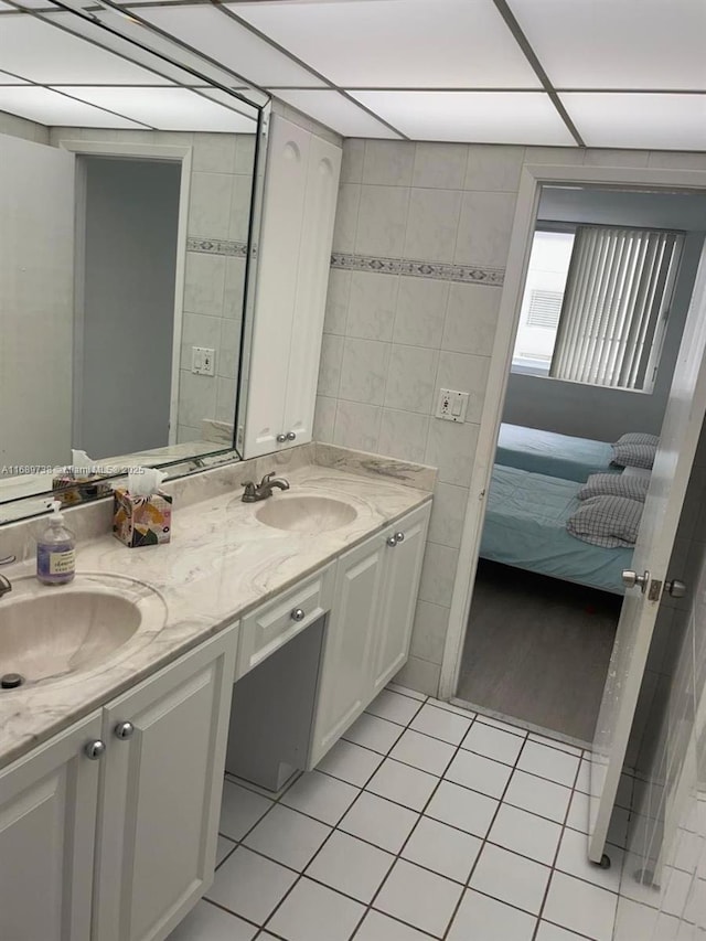 bathroom with tile patterned floors, vanity, and tile walls