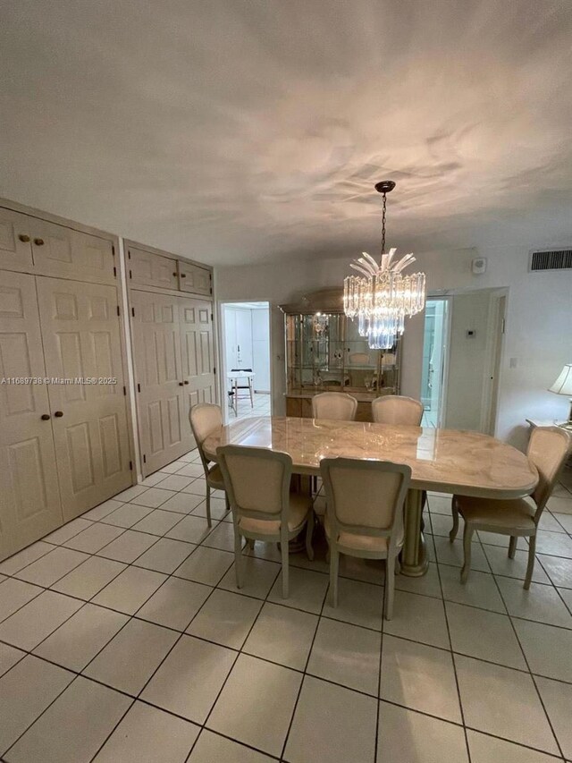 unfurnished dining area featuring light tile patterned floors and an inviting chandelier