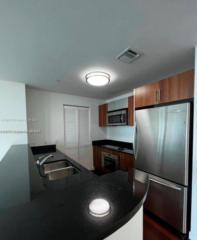 kitchen with kitchen peninsula, sink, and stainless steel appliances