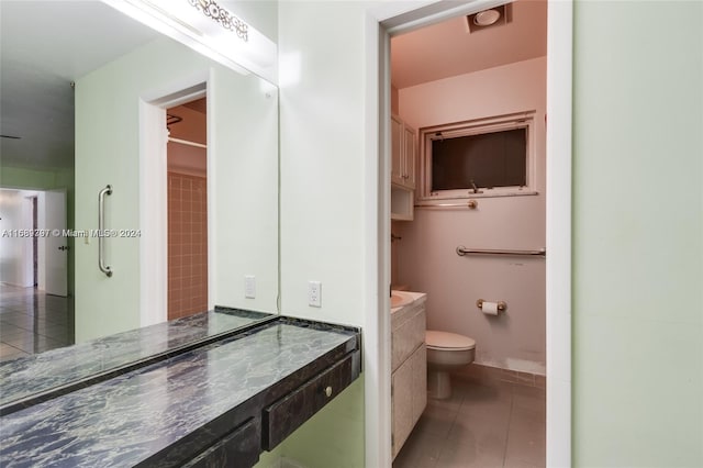 bathroom featuring vanity, tile patterned flooring, and toilet