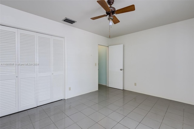 unfurnished bedroom with a closet, ceiling fan, and light tile patterned floors