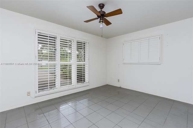 empty room with ceiling fan and tile patterned floors