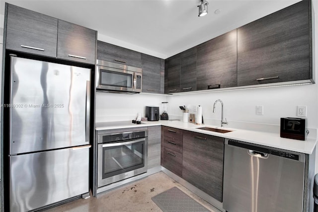 kitchen featuring dark brown cabinetry, sink, and appliances with stainless steel finishes