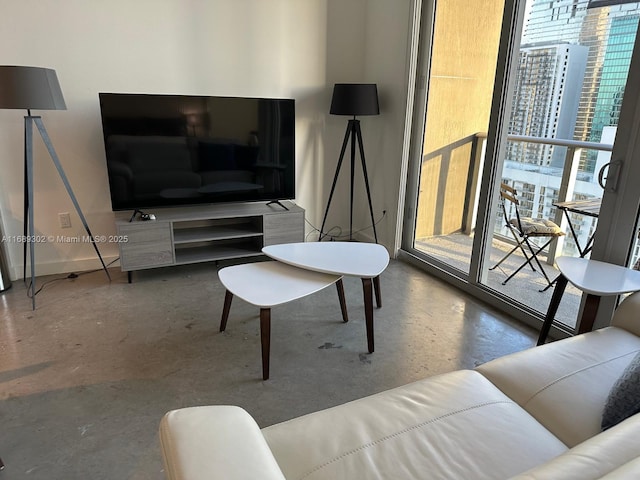 living room featuring concrete flooring and a wealth of natural light