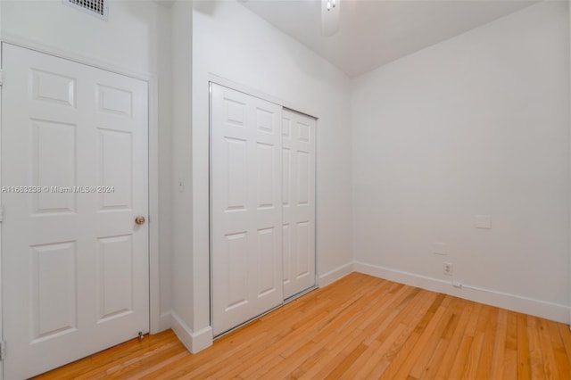 unfurnished bedroom with wood-type flooring and a closet