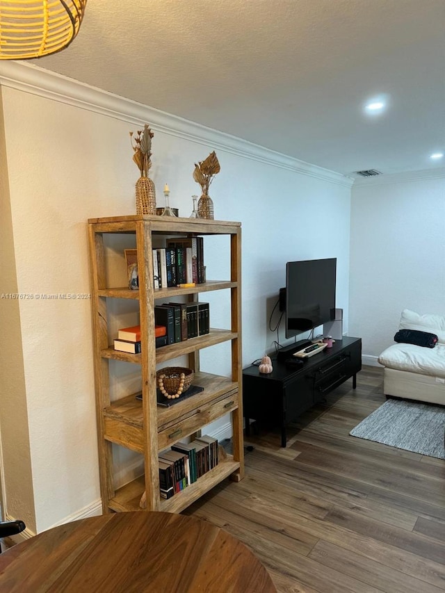 living room featuring wood-type flooring and crown molding