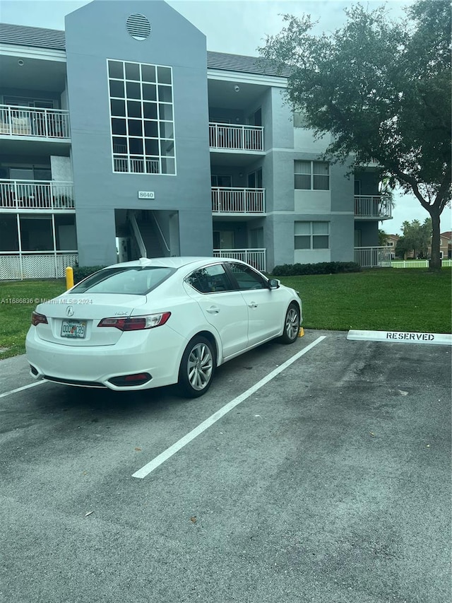 view of parking with a yard