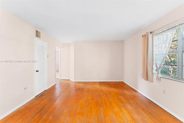 unfurnished room with hardwood / wood-style flooring