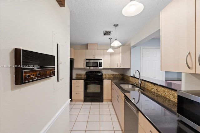 kitchen with dark stone counters, sink, a textured ceiling, decorative light fixtures, and stainless steel appliances