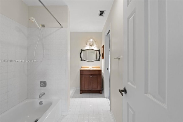 bathroom with tile patterned floors, vanity, and tiled shower / bath