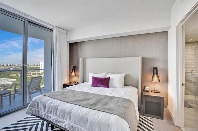 bedroom featuring expansive windows and access to outside