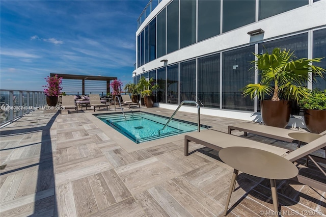 view of pool featuring a hot tub and a patio