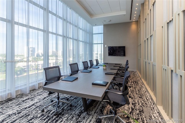 office area featuring a raised ceiling, expansive windows, and a high ceiling