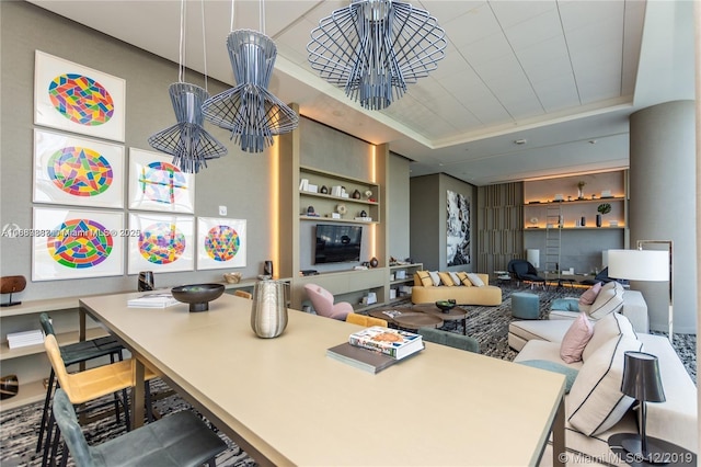 living room with a tray ceiling and built in features