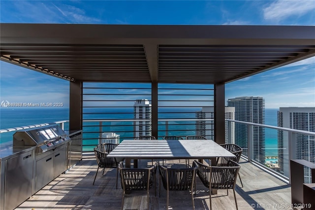 balcony featuring a water view and exterior kitchen