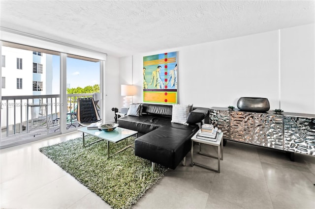 living room featuring a textured ceiling and a wall of windows