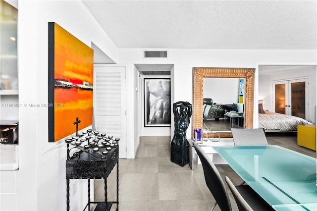 interior space featuring french doors and a textured ceiling