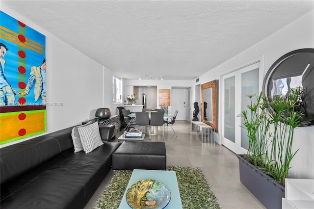 living room featuring a textured ceiling and french doors