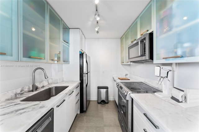 kitchen featuring green cabinets, sink, light stone countertops, appliances with stainless steel finishes, and white cabinetry