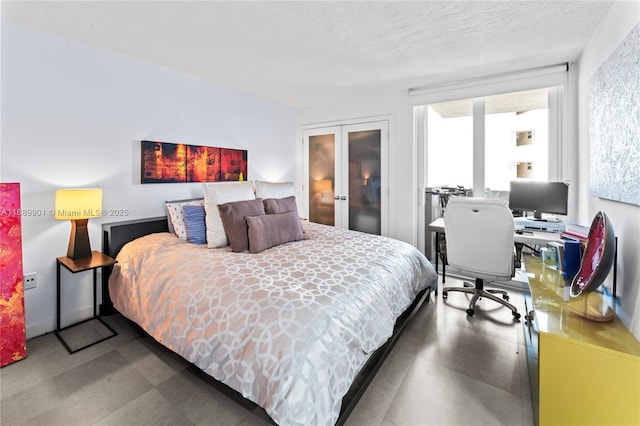 bedroom featuring a textured ceiling and french doors