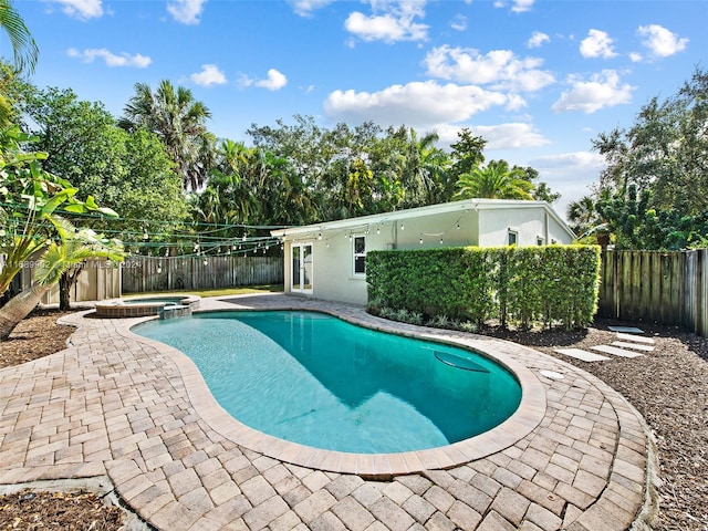 view of swimming pool with a patio and an in ground hot tub