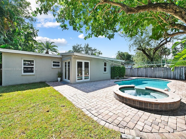 view of pool featuring a yard, an in ground hot tub, french doors, and a patio area