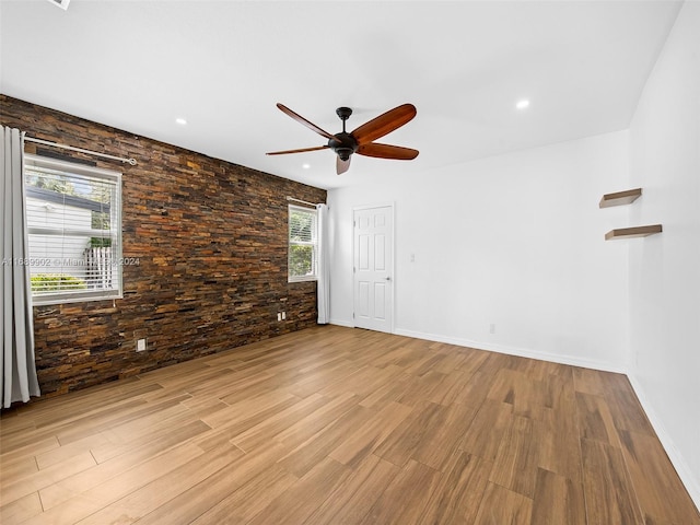 empty room with ceiling fan, a wealth of natural light, and light hardwood / wood-style floors