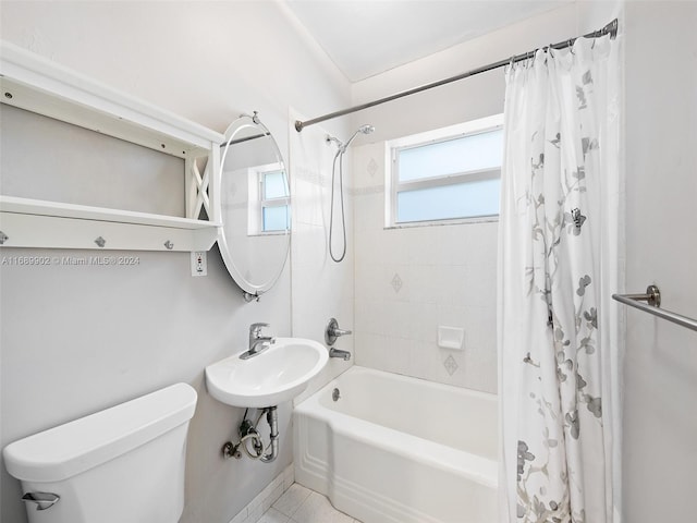 full bathroom with shower / tub combo with curtain, tile patterned floors, sink, and toilet