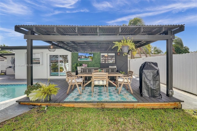 wooden terrace featuring a fenced in pool and area for grilling